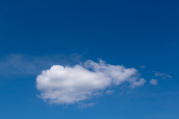 A white cloud floating alone against a blue sky
