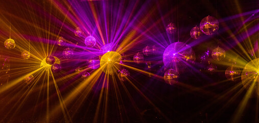 abstract background with lights mirror disco balls in the light of multi-colored rays.