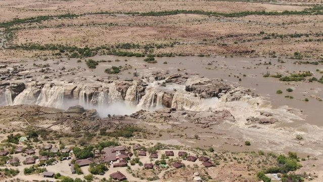 Aerial view of Augrabies Falls in flood. Pull back to reveal vast arid landscape around