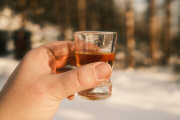 Ein Schnapsglas in der Hand halten