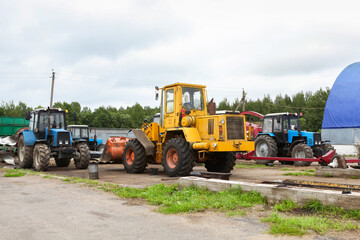 Fototapeta na wymiar Agricultural machinery, tractors and equipment outdoors, near the garage, ready to work in the field.