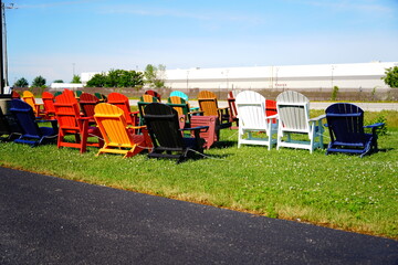 Colorful wooden lawn chairs are set up outside to be sold 