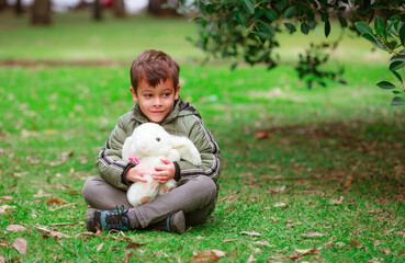 Hispanic boy with a toy hare in the park