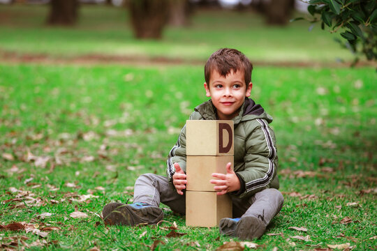 hispanic boy playing with blocks in the park