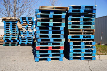 Wooden blue shipping pallets sit outside on the shipping dock.