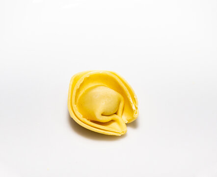 Traditional Italian tortellini (capeletti, agnolini) fresh pasta stuffed with chicken, special for preparing soup on cold nights, insulated on a white background
