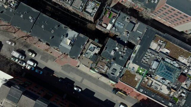 Fly above residential urban neighbourhood. Top down view of leafless trees between rows of apartment houses. Boston, USA