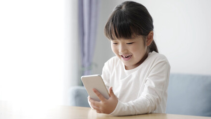 リビングでスマートフォンを使う女の子