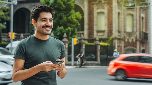 Handsome mexican man smiling with email in his hands sending text messages.