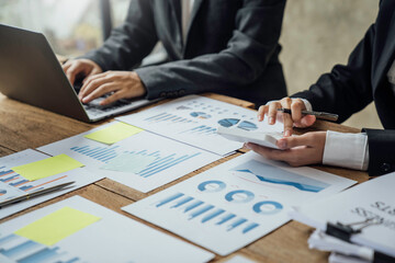 Close up business adviser partnership coworkers using a tablet to chart company financial statements report and profits work progress and brainstorming, discussing and analyzing business strategy.