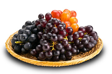 Bunches of ripe red grapes, black grapes and purple grapes in bamboo plate.