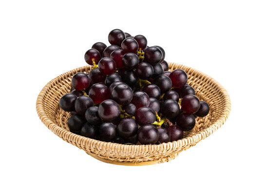 Bunch of ripe purple grapes in bamboo basket isolated on white background.