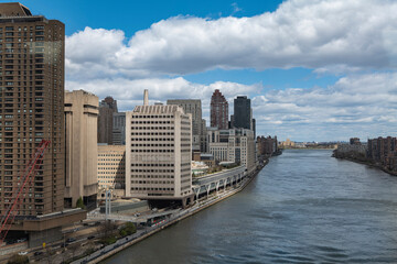 New York City skyscrapers on the river canal have a cloudy and blue sky background. High-quality photo