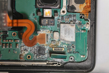 Fototapeta premium repair phone. rust on chip. microchip after water. computer hard drive. closeup of electronic part of phone circuit board. dust part of phone. repair microship on phone. dust and rust on metal part.