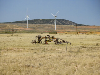 Abandoned Antique Road Grader Rusting on a Farm with Wind Turbines in Background