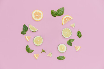 Citrus and Basil in a circle on a pink background