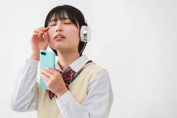 ヘッドフォンで音楽を聴く女子高校生