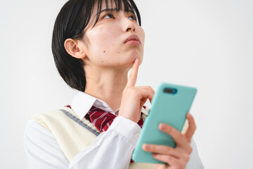 スマートフォンを持って困惑する女子高校生