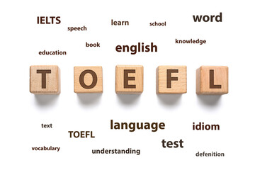 Text TOEFL made of wooden cubes and different words on white background. Concept of studying English - obrazy, fototapety, plakaty