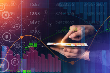 Hands of economist with tablet computer using virtual screen with diagrams on dark background