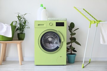 Green washing machine in modern laundry room
