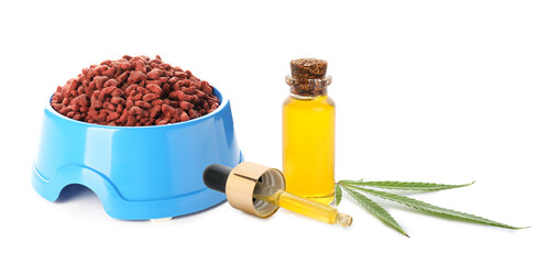 Dry pet food in bowl and bottle of hemp oil on white background