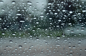 Glass water droplets. Blurred background. Road with cars. Concept. Rainy season driving on bad weather days. poor visibility feels dangerous, be careful