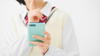 スマートフォンを持って困惑する女子高校生