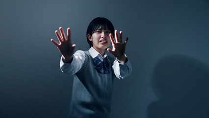 手で払いのける女子高校生