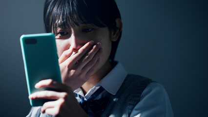 スマートフォンを見て不安になる女子高校生