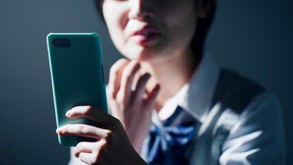 スマートフォンを見て不安になる女子高校生