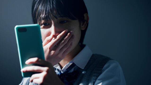 スマートフォンを見て不安になる女子高校生