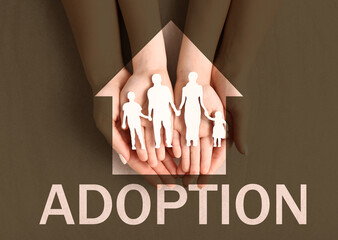 Hands of woman and child with figure of family. Adoption concept