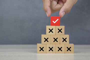 Hand choose wooden block stack with check mark and cross symbol for customer survey service and...