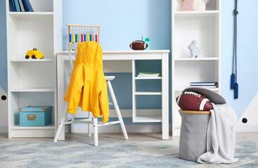 Basket with rugby ball and modern furniture in children's room