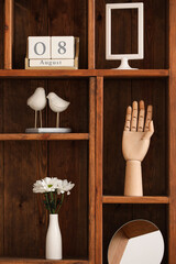 Shelving unit with stylish decor, mirror and flowers in vase, closeup