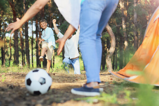 Little boy playing soccer with his father and grandfather in forest - Powered by Adobe