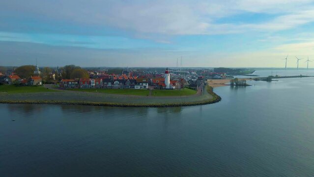 Urk Flevoland Netherlands, a sunny spring day at the old village of Urk with fishing boats at the harbor. Urk harbor. Urk Lighthouse at the lake Ijselmeer