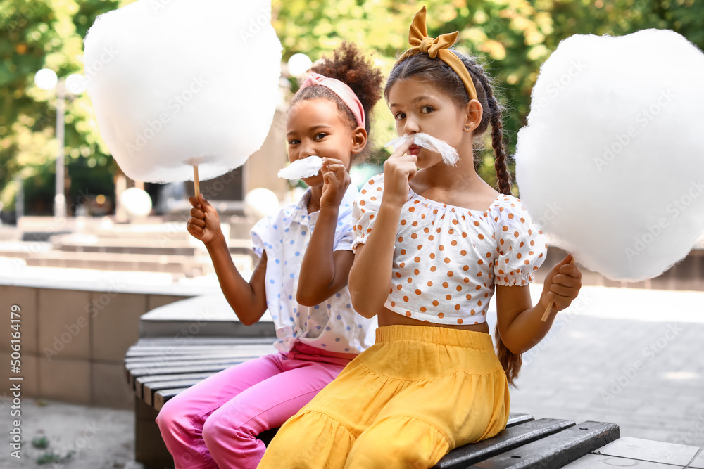 Wall mural Cute little girls with cotton candy outdoors