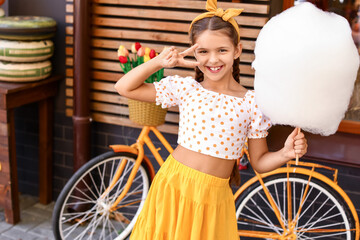 Cute little girl with cotton candy outdoors
