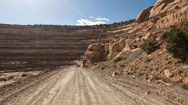 Moki Dugway Utah mountain jogger. Roadway carved from a mountain cliff. Scenic Backway dirt road drastically switches backs the side of a cliff very narrow. Built as mining and uranium road.