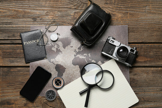 Guide's supplies with mobile phone and passport on dark wooden background
