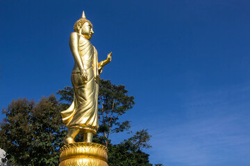 Nan Thailand - December 16 2016: The standing Buddha statue at Phrathat Khao Noi temple Nan Province Thailand standing in front of Nan city view.