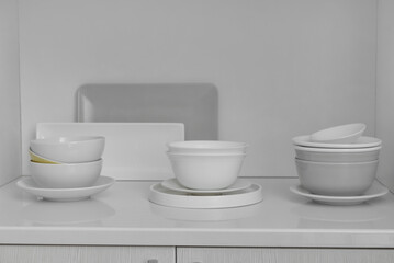 Shelf with beautiful dinnerware in kitchen