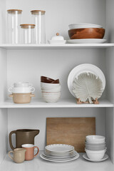 Shelves with beautiful dinnerware in kitchen - obrazy, fototapety, plakaty