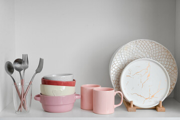 Shelf with beautiful dinnerware in kitchen