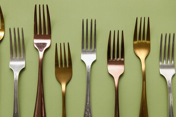 Many different forks on green background, top view