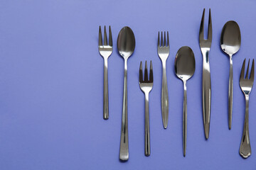 Many different cutlery on color background, top view