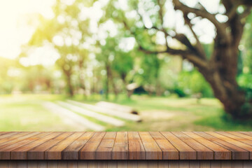 Empty wooden table top and Abstract blurred light bokeh and blur background of garden trees in sunlight. product display template with copy space.