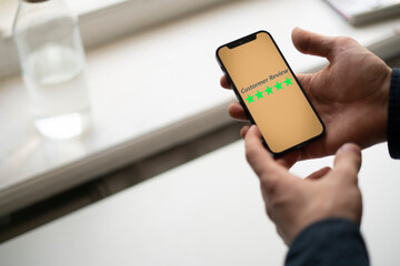 smartphone screen with five star quality review, positive feedback
